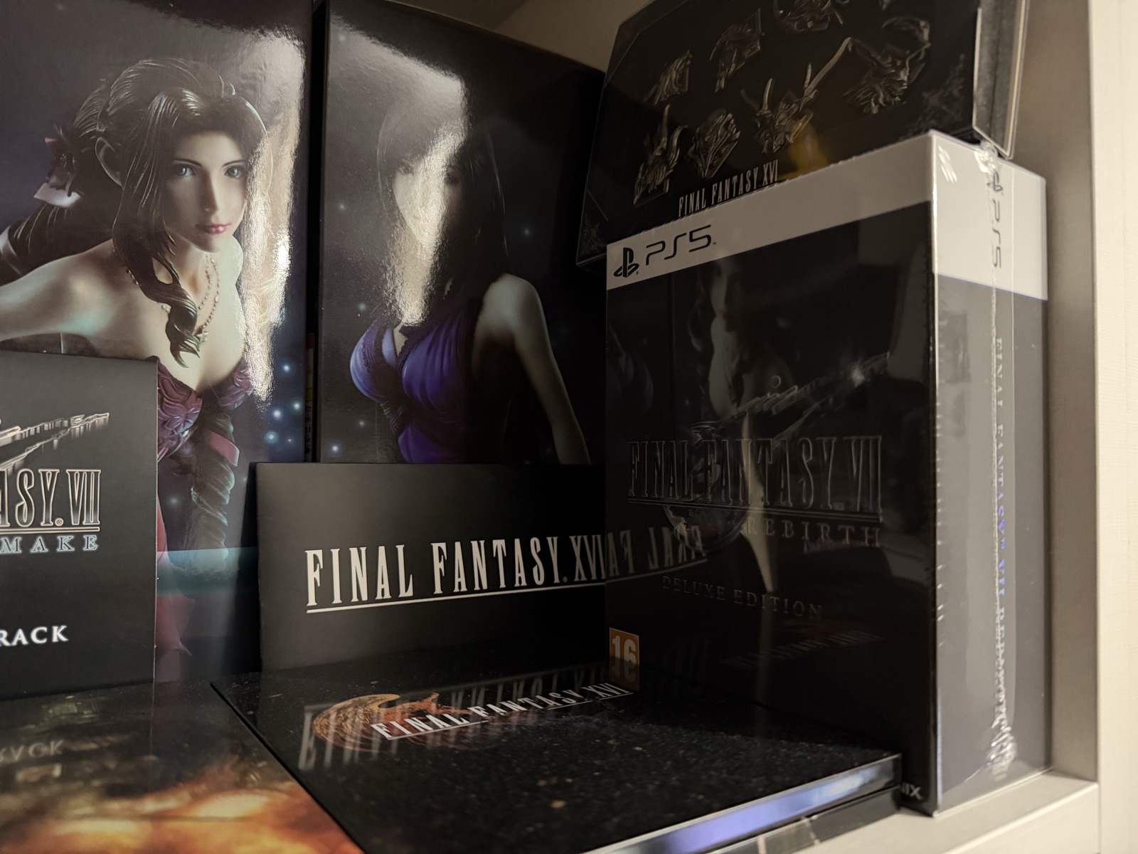 Edición física de Final Fantasy VII Rebirth sin abrir junto a otros objetos de colección de Final Fantasy