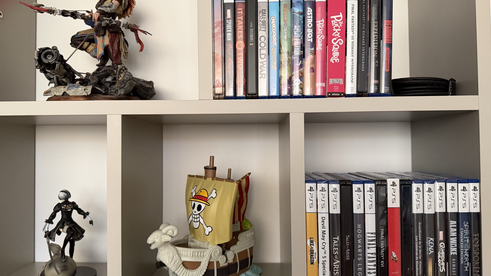 Estantería con juegos físicos de PlayStation y figuras de videojuegos